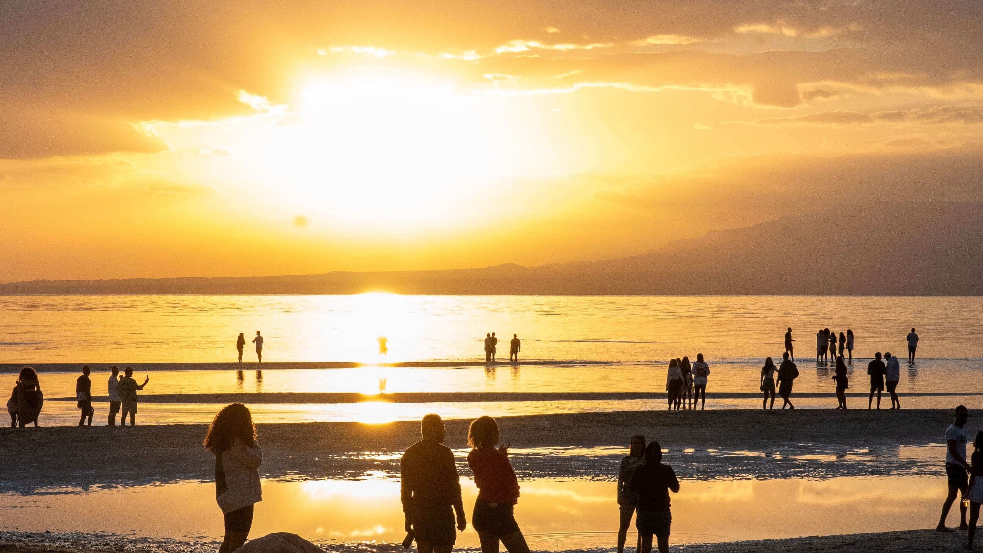 Sunset over the shallow lagoon at Soul, Ras Sudr — people on the sand and standing far out in ankle-deep water