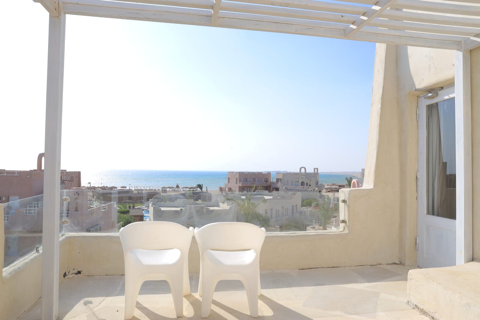 Two terrace chairs facing the sea outside the Special Deluxe room